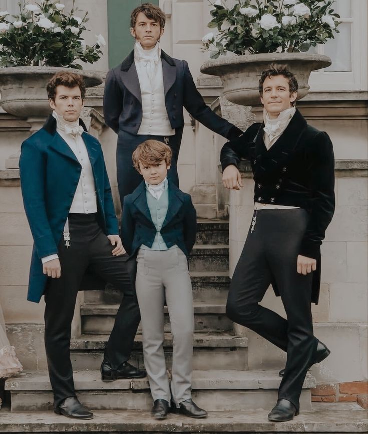 four men in formal wear standing on steps