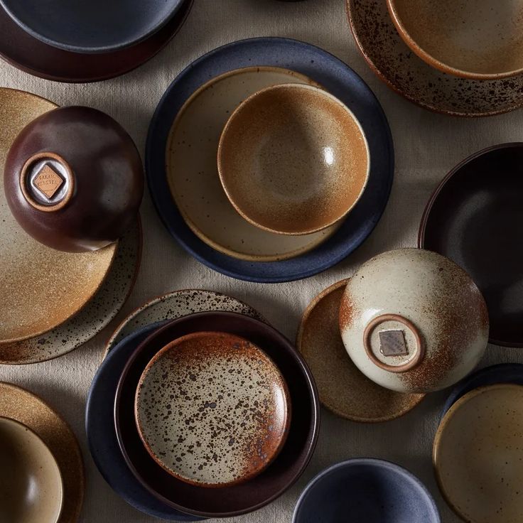 a table topped with lots of different types of plates and bowls on top of each other