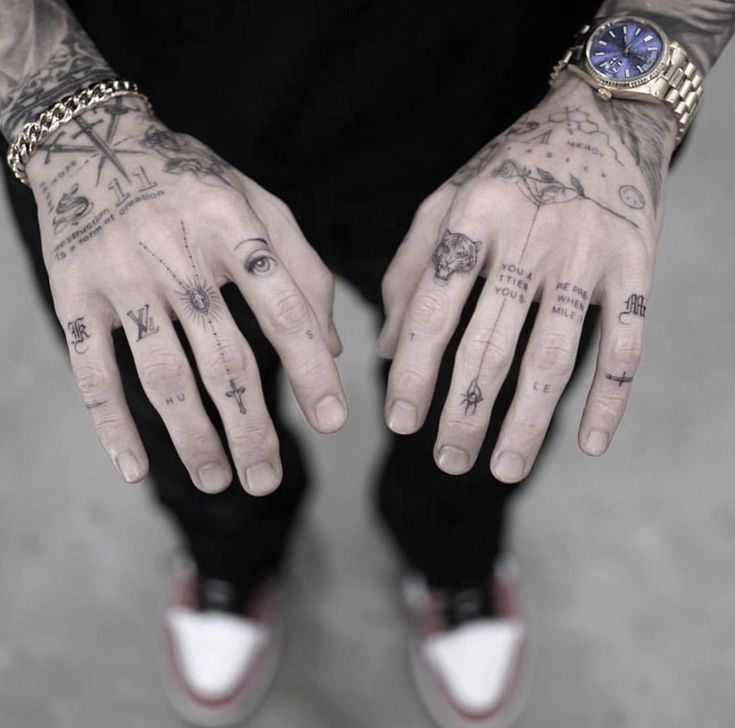 a man with tattoos on his hands and wrist