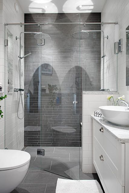 a bathroom with a sink, toilet and shower stall in the middle of the room