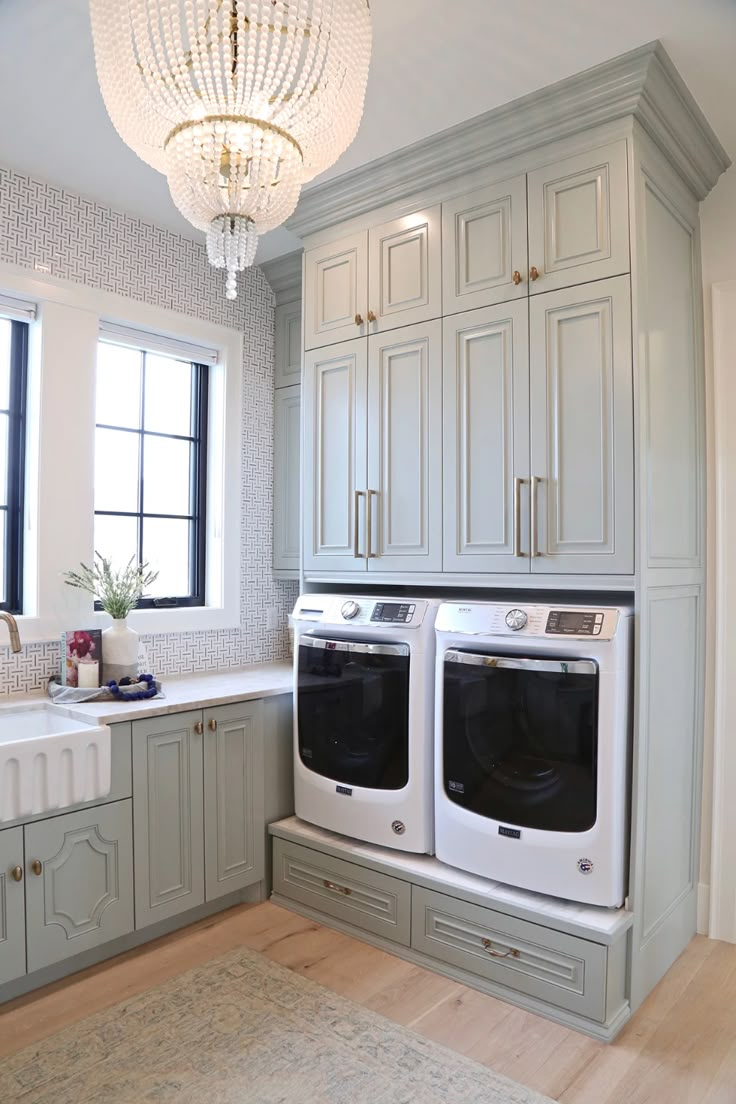 a kitchen with two washers in it and a chandelier hanging from the ceiling