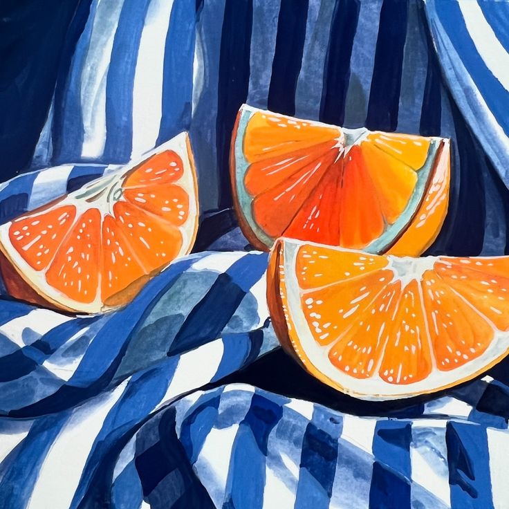 two oranges cut in half sitting on blue and white striped fabric, with stripes