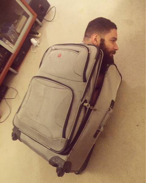 a man sitting on the floor with his luggage