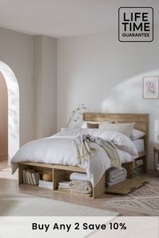 a bed with white linens and pillows in a bedroom next to an arch doorway