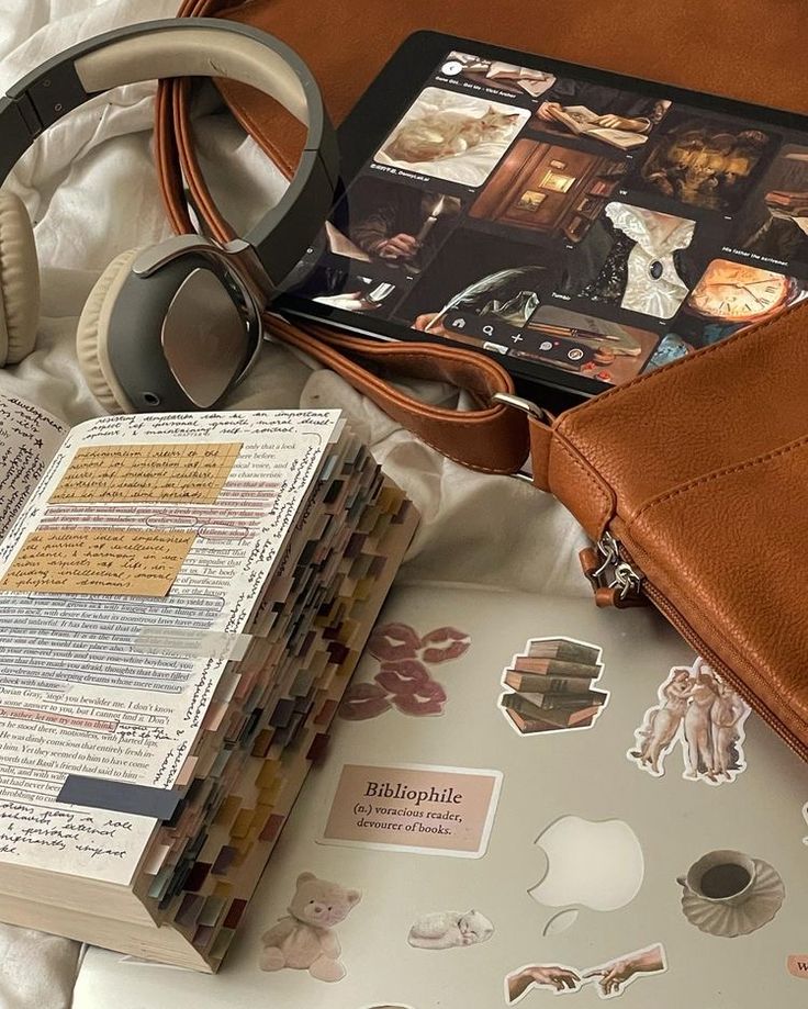 an open book and headphones on top of a bed