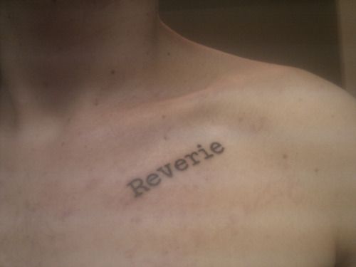 a shirtless man with the word reverie tattooed on his chest