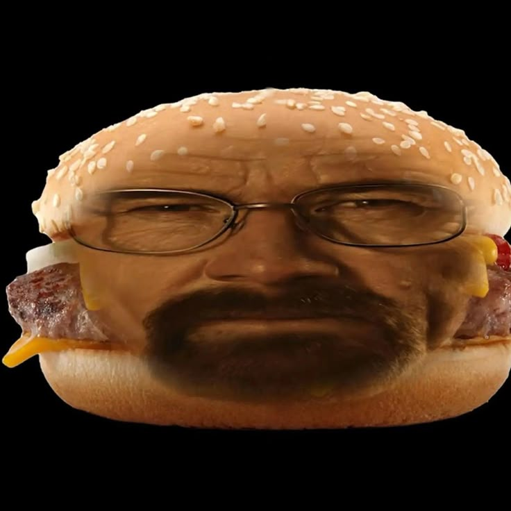 a man with glasses and a hamburger in his mouth