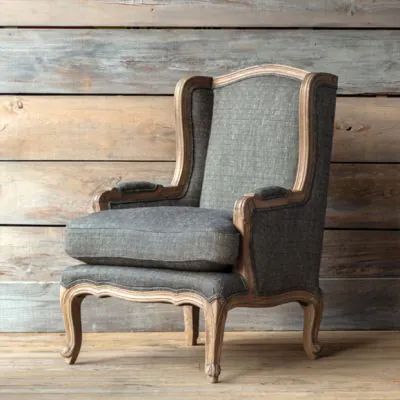 an old chair sitting in front of a wooden wall