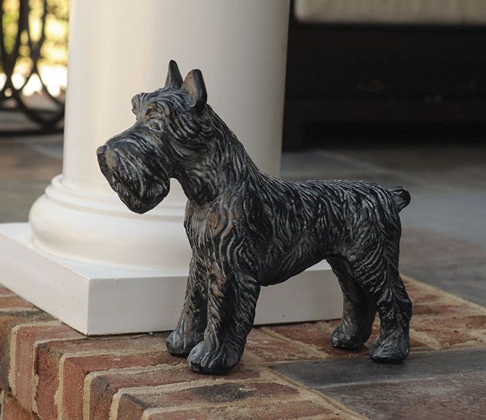 a statue of a dog standing on top of a brick floor next to a white column