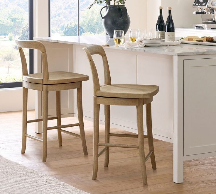 two wooden chairs sitting in front of a counter