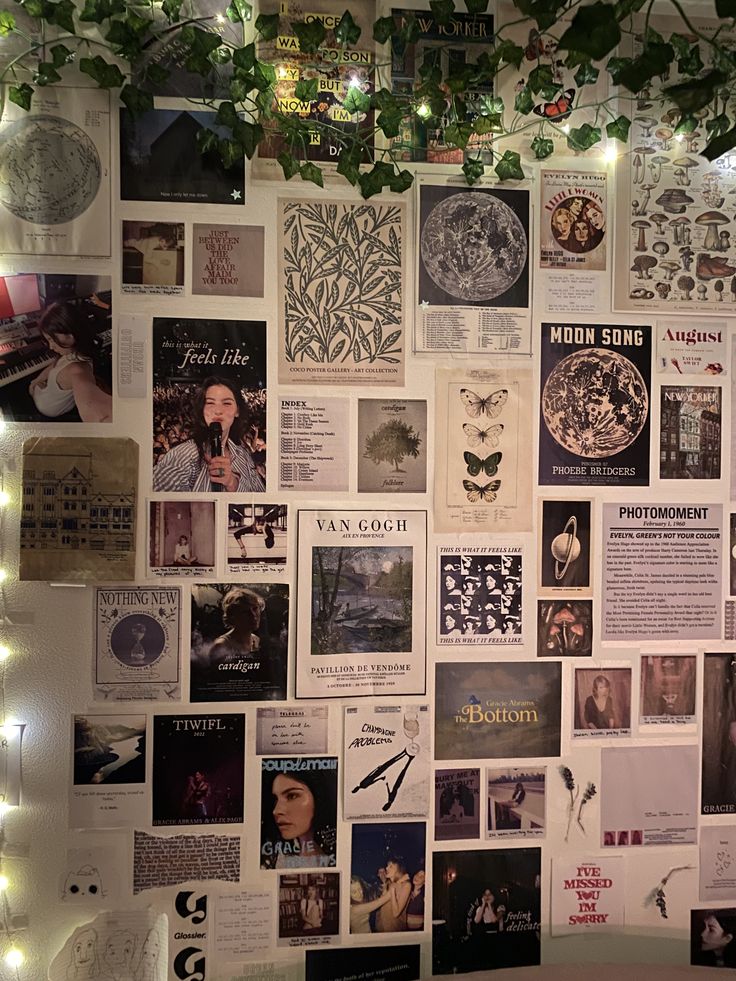 a wall covered in posters and lights with plants growing on the top of it's sides