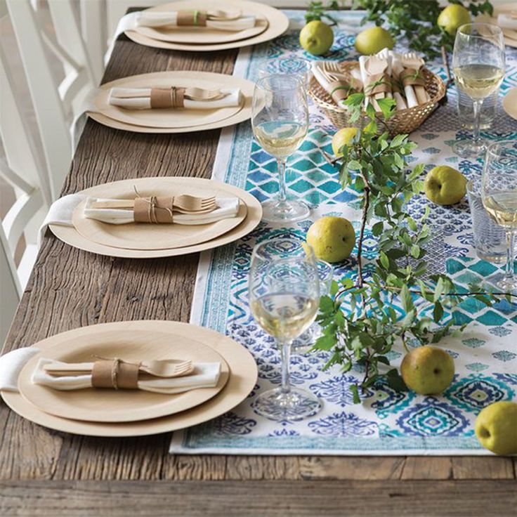 the table is set with plates, knives and pears on it's placemat