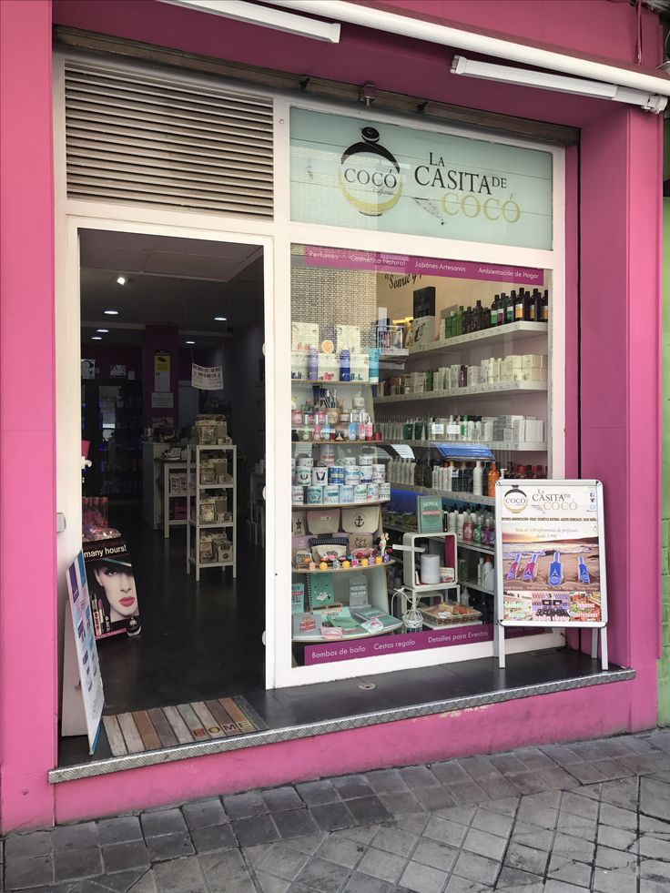 a store front with the door open and shelves full of products in it's windows