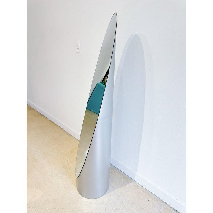 a large metal sculpture sitting next to a white wall