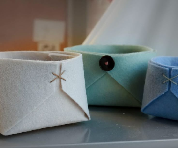 three different colored paper containers sitting on top of a table