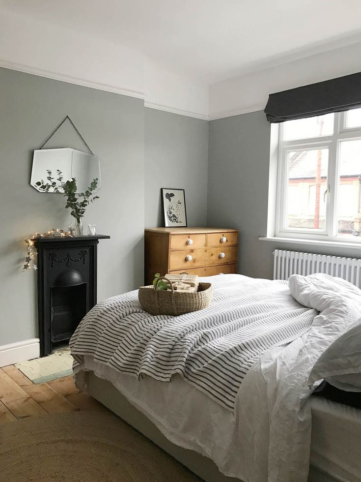 a bedroom with a bed, dresser and window