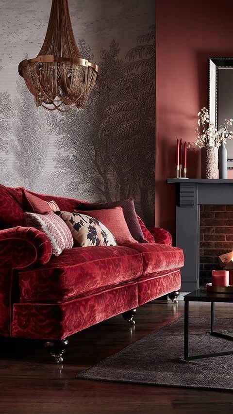 a living room with red velvet couches and a chandelier hanging from the ceiling