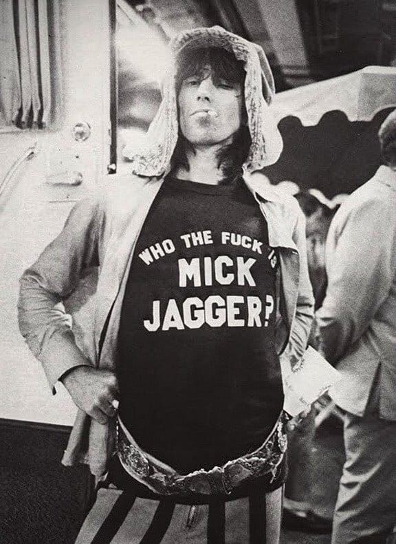 a man wearing a shirt that says who the puck is mick jagger?