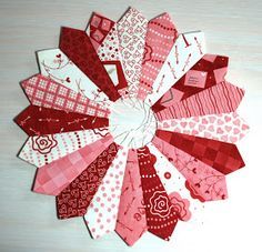 several pieces of fabric are arranged in the shape of a flower on a white surface