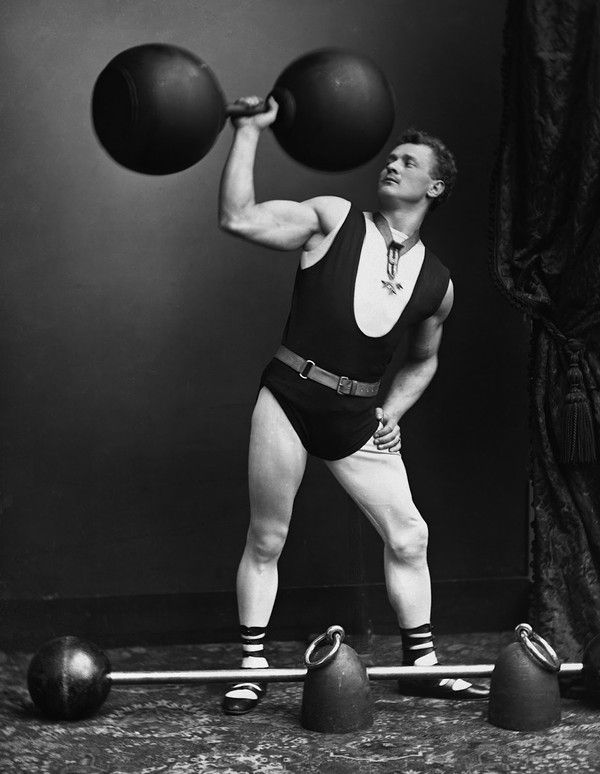 a man holding two balls in his hands while standing on one leg and lifting the other