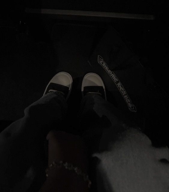 someone is sitting in the dark with their shoes on