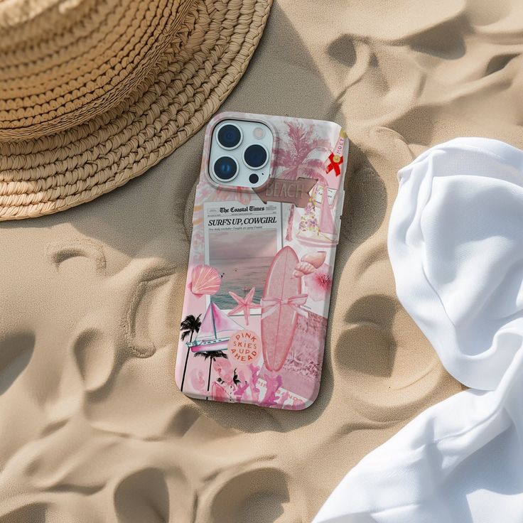 an iphone case sitting on top of sand next to a straw hat and beach towel