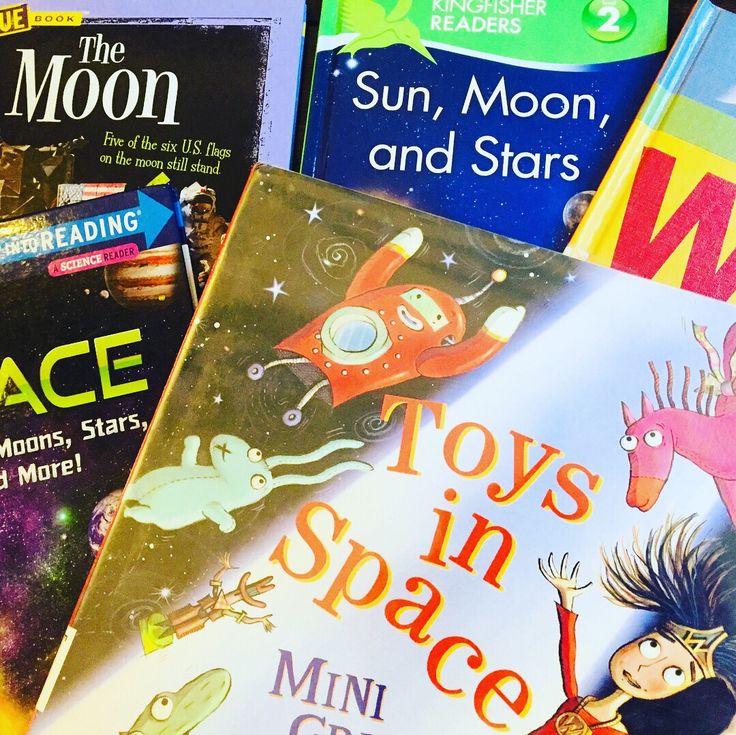 several children's books stacked on top of each other, including toys in space