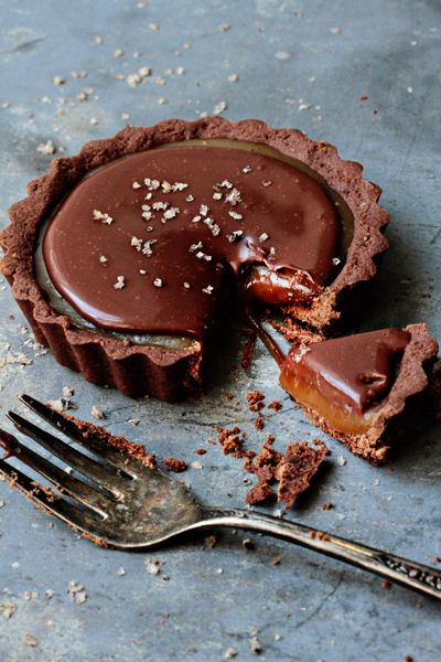 a chocolate tart with a bite taken out of it and a fork next to it