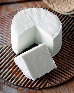 two pieces of cheese sitting on top of a wooden table