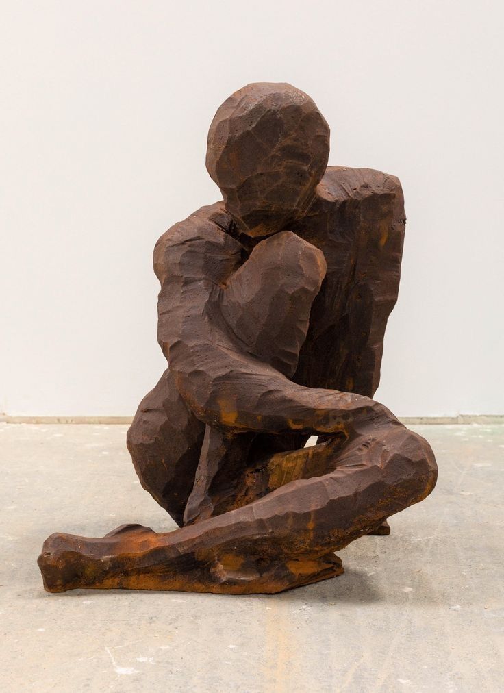 a wooden sculpture sitting on top of a white floor