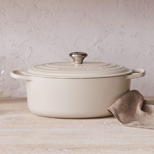 a white casserole sitting on top of a wooden table