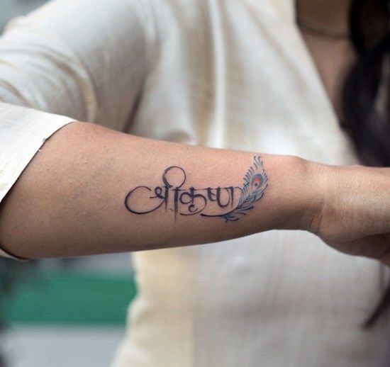 a woman with a tattoo on her arm that says, happy in cursive writing