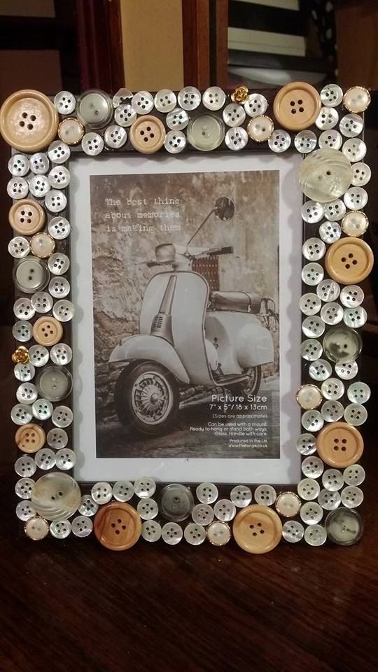 an old photo frame is decorated with buttons and a scooter in the middle