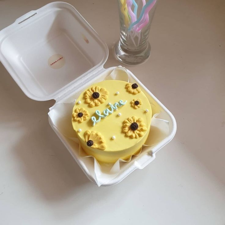 a yellow cake in a plastic container on a table