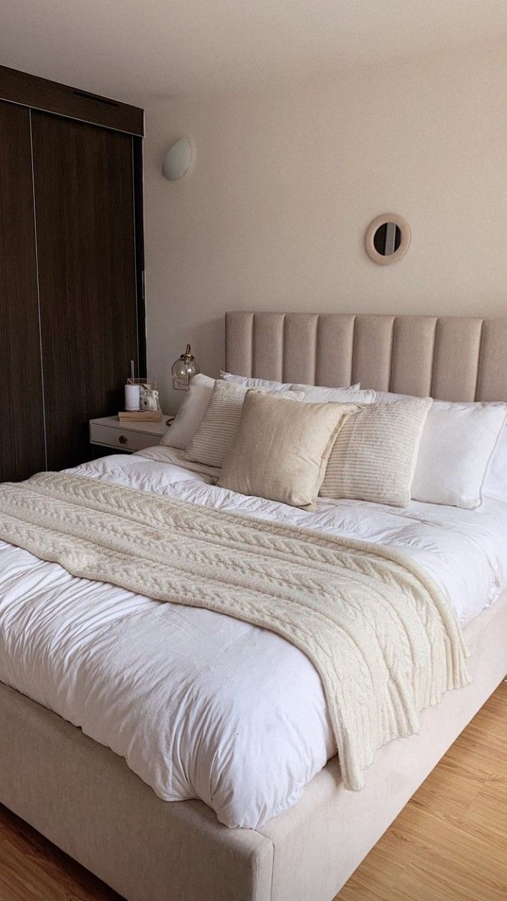 a large bed with white sheets and pillows