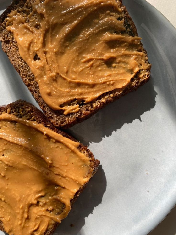 two pieces of bread with peanut butter spread on them