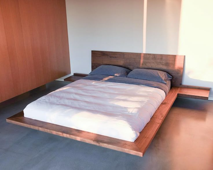 a bed sitting in the middle of a room with wooden headboard and foot board