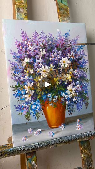 a painting of flowers in a vase on an easel