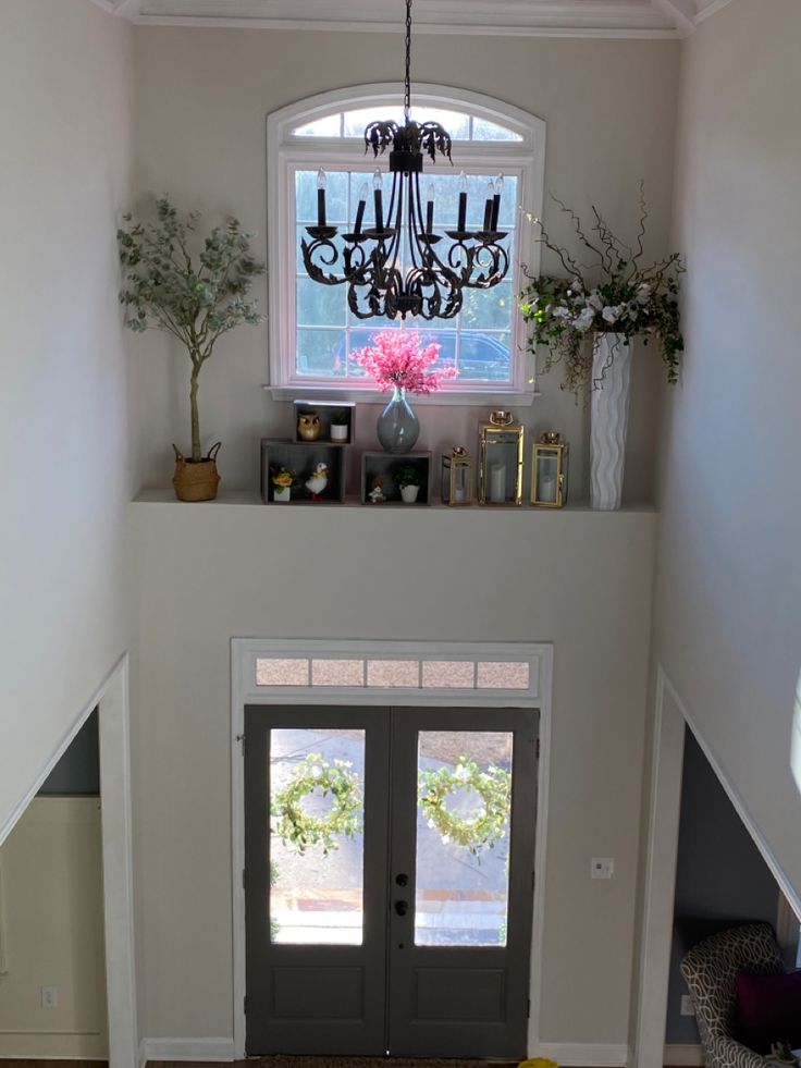 an entry way with a chandelier and two doors leading to the second floor