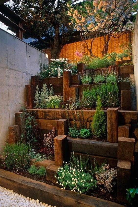 an outdoor garden with wooden steps and plants growing on the sides, along with gravel