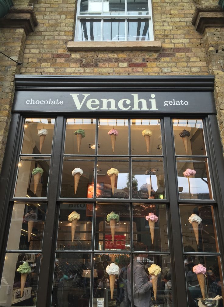 an ice cream shop front with many cones in the window