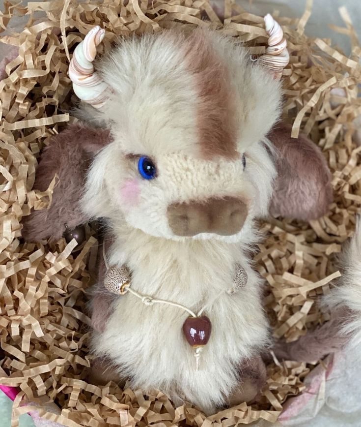 a small stuffed animal sitting in some wood shavings