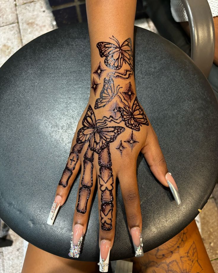 a woman's hand with butterfly tattoos on it