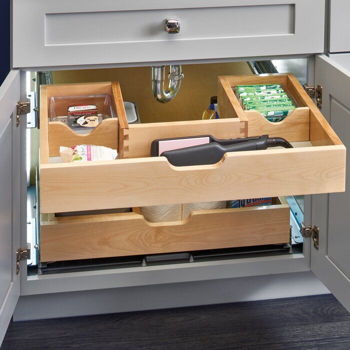 an open drawer in a kitchen with items inside