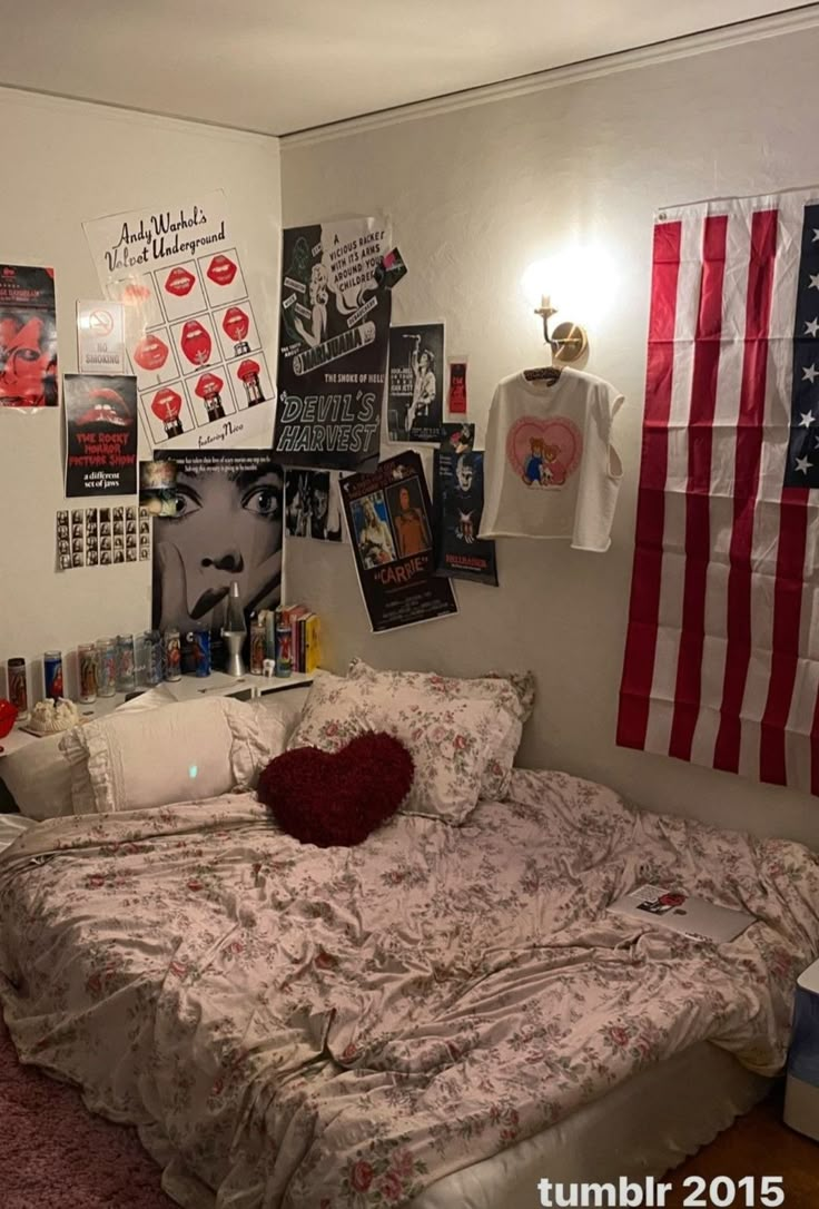 a bedroom with an american flag on the wall and pictures above the bed in it