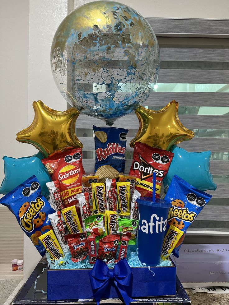 a gift basket filled with candy, balloons and confetti