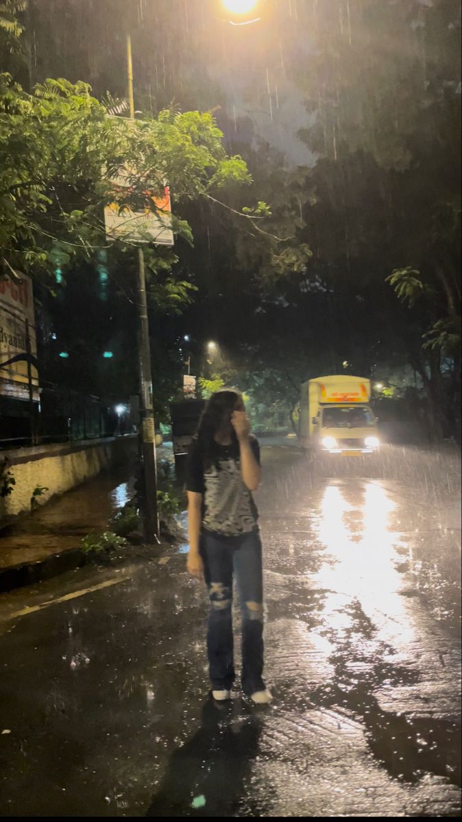 a woman standing in the rain talking on her cell phone