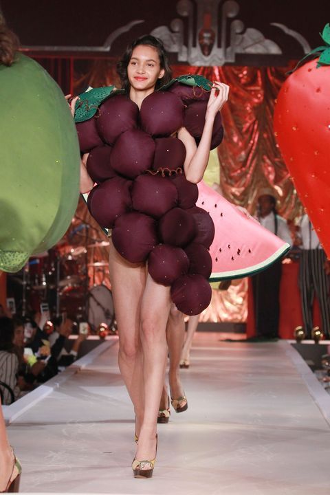 a woman is walking down the runway in a costume made out of fruits and vegetables