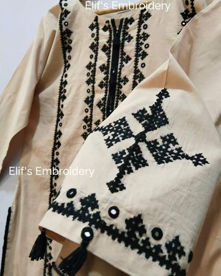 an embroidered shirt with black and white designs on it