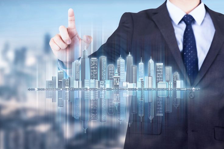 a man in a business suit is touching the cityscape with his finger and pointing to it